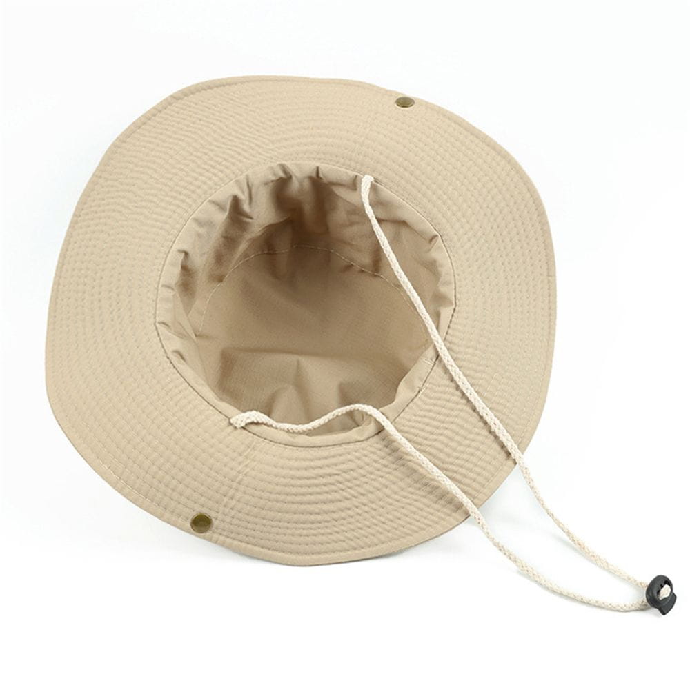 Sombrero tipo cubo de pescador de ala ancha en color beige, con cierre mediante cordón y costuras reforzadas, diseñado para protección solar en verano.