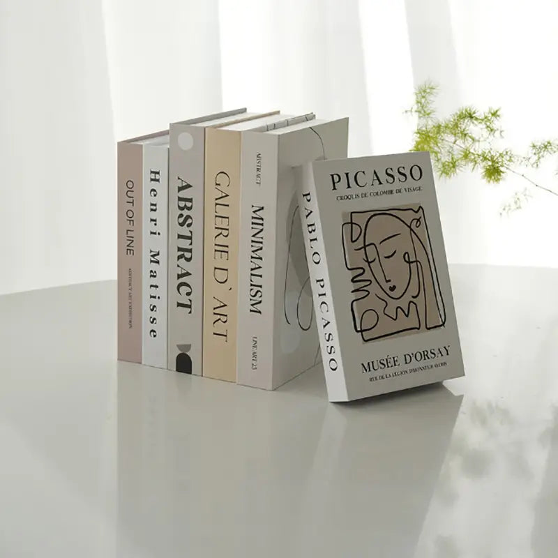 A sleek minimalist bookshelf display featuring decorative fake books with clean white spines and black typography for coffee table home decor.