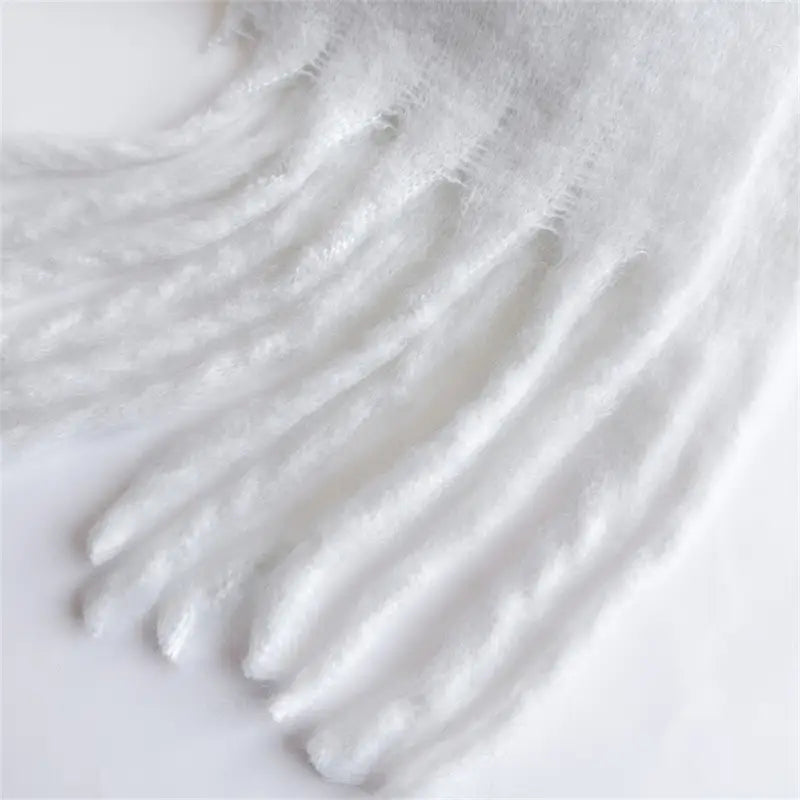 Weiße, flauschige Quasten aus weich strukturierter Wolle an einem Damenschal mit Cashmere-ähnlichem Gefühl für den Winter