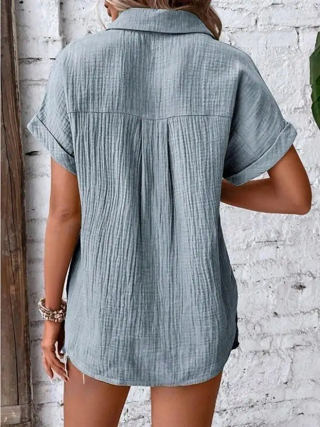Light blue women cotton short sleeve button up shirt dress with subtle textured fabric and collar.