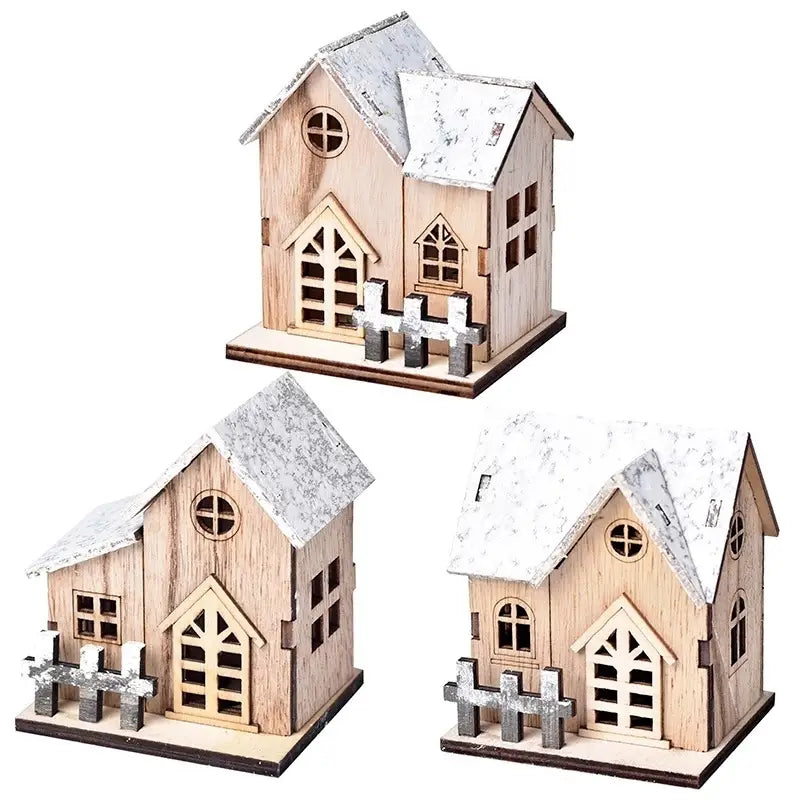 Beleuchtete Holz-Weihnachts-Haus-Dekoration mit schneebestäubten Dächern und dekorativen Zäunen mit natürlicher Holzoberfläche.