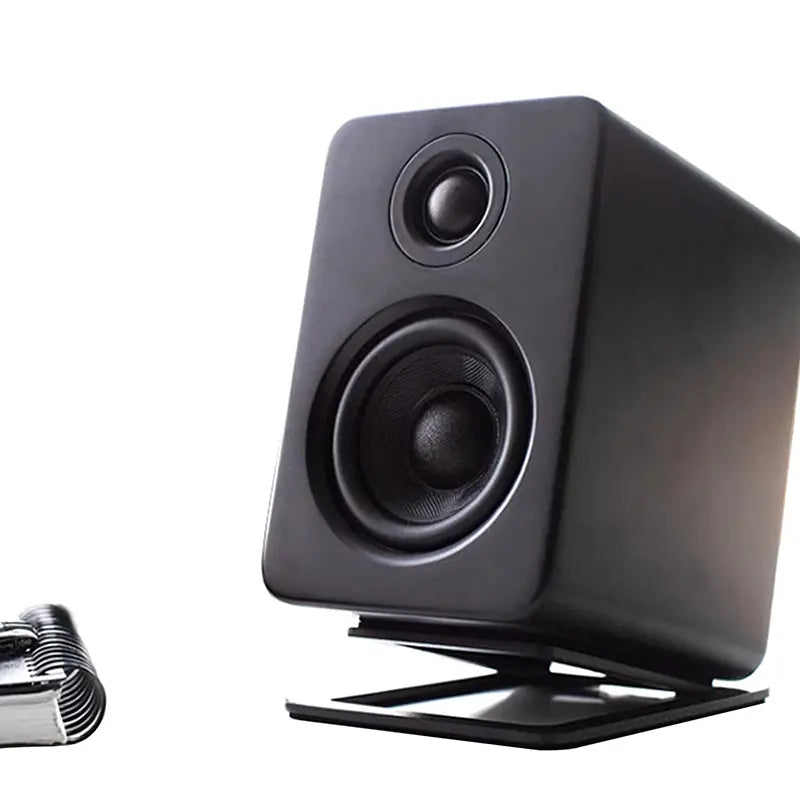 black rectangular speaker with a matte finish featuring two circular drivers mounted on a matching aluminum desktop speaker stand with a 16 degree tilt pair