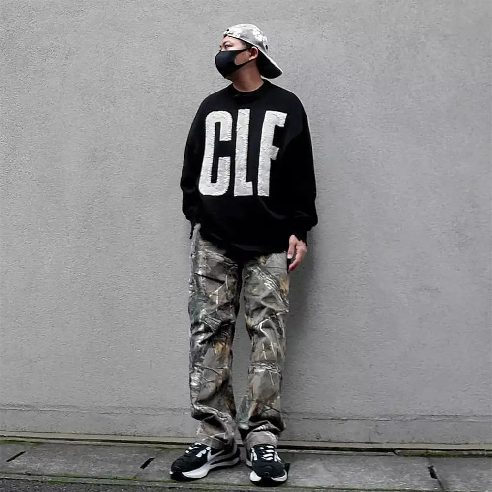 長袖スウェットのデザインで、胸元に太い白い「clf」レタリングをあしらったブラックのオーバーサイズニットセーター。