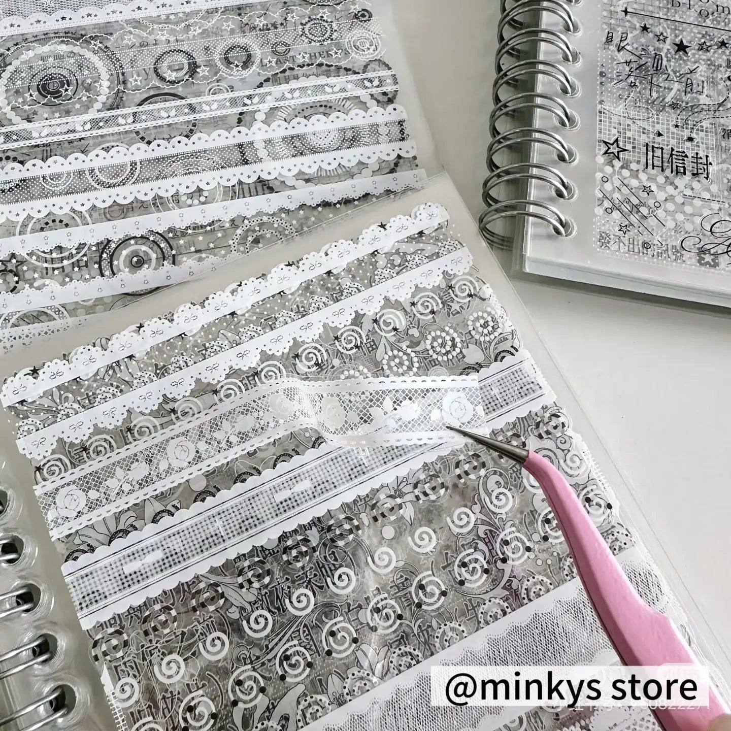 eine Sammlung zarter transluzenter Washi-Tapes mit filigranen Schwarz-Weiß-Spitzenmustern und gekräuselten Kanten aus dem Produkt „kawaii kpop sticker book spiral journal stationery“