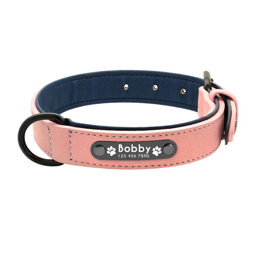 Customized leather dog collar in pink leather with navy blue interior featuring a black metal nameplate engraved with the name Bobby and paw prints for personalization and customization information.