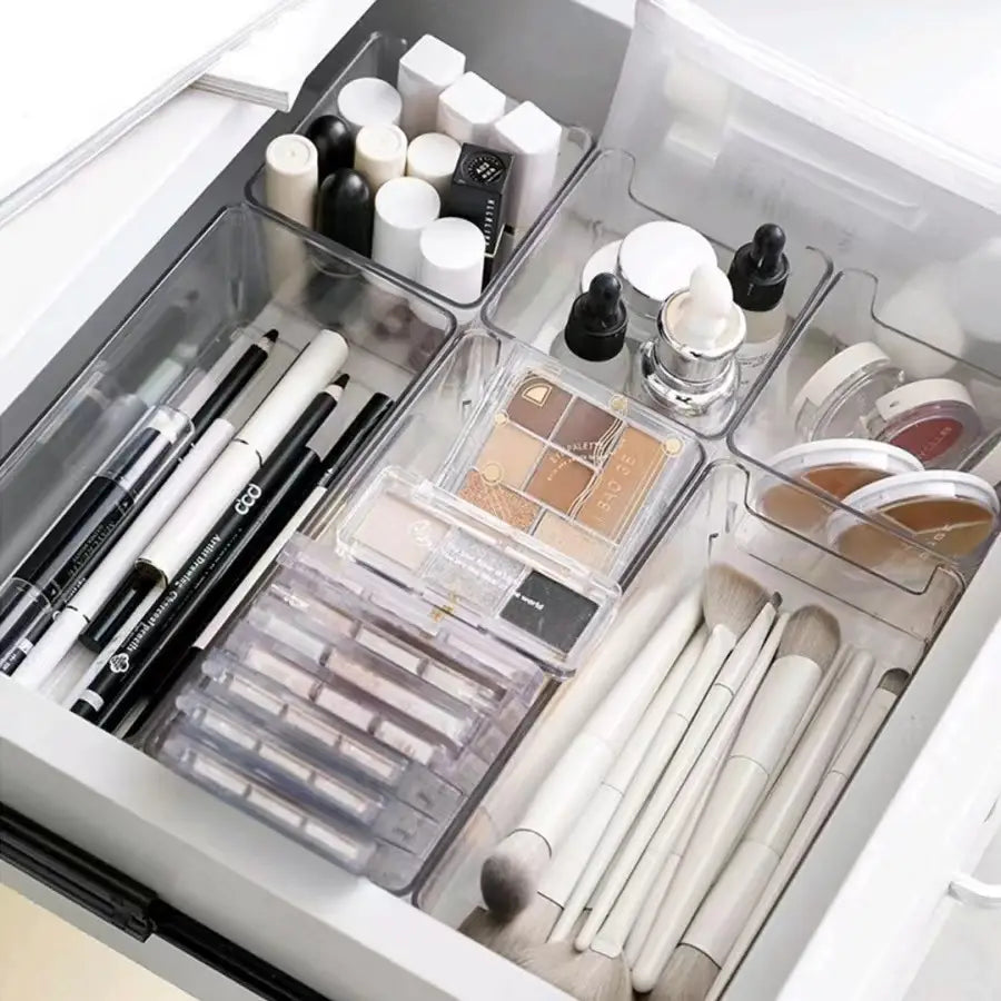 Organizador de maquillaje de plástico transparente y recipiente de almacenamiento para cajones con múltiples compartimentos que guardan brochas, lápices y paletas para el almacenamiento de maquillaje.