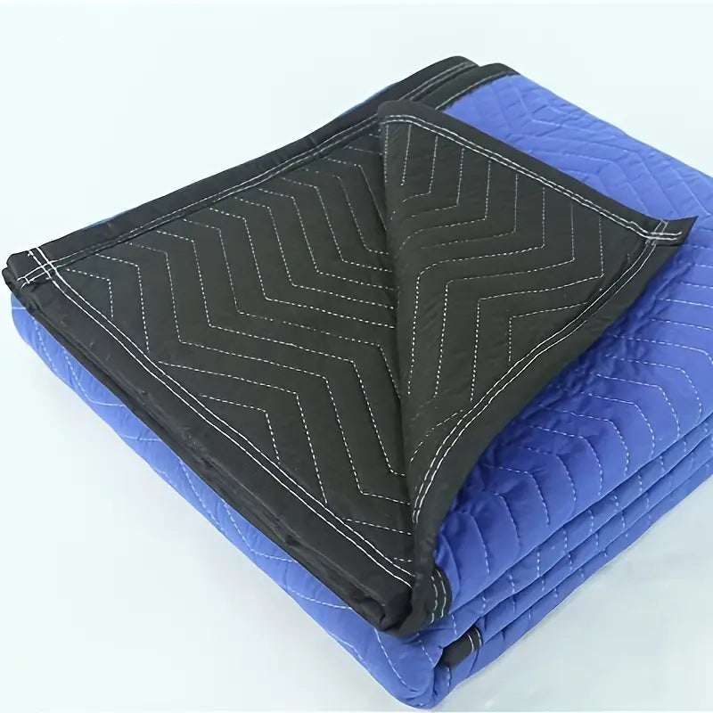 Robuste Umzugsdecke zur Möbelabdeckung, die die Rückseite zeigt, mit einer blauen gesteeppten Oberfläche und einer schwarzen, mit Zickzackstich vernähten Unterseite, mit weißem Stich entlang der Kanten.