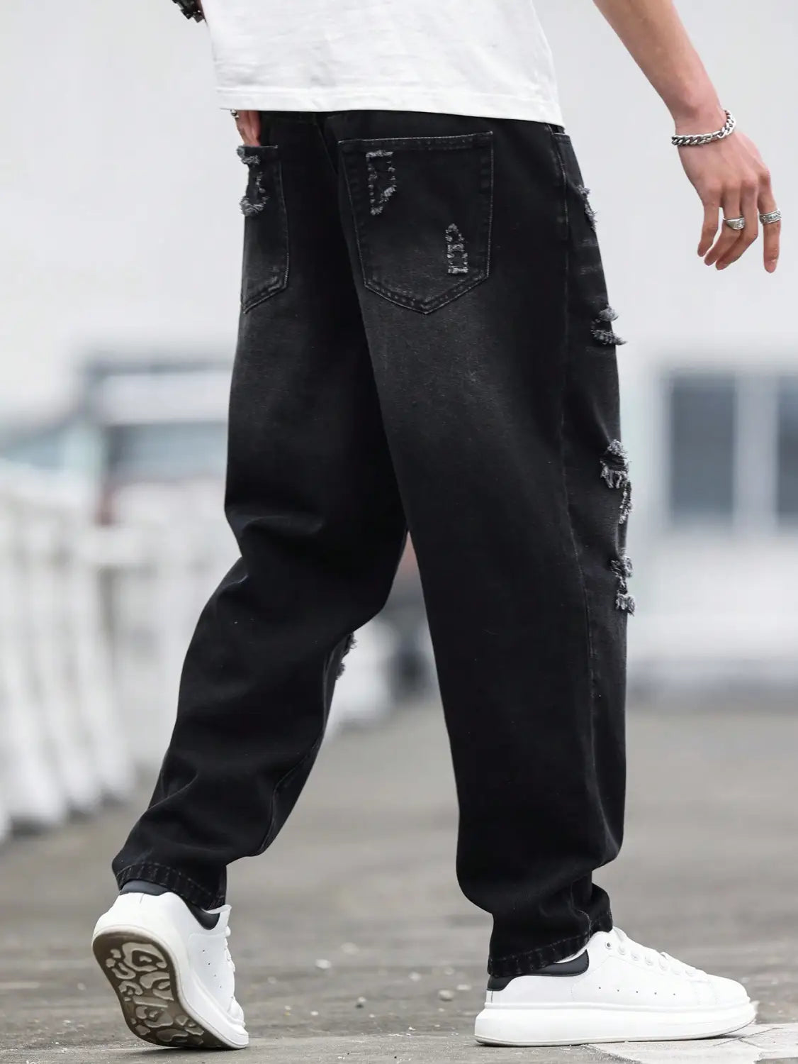 Herren schwarze zerrissene Denim-Haremshosen aus abgenutztem Denim mit zerrissenen Details und dekorativer Ziernaht.