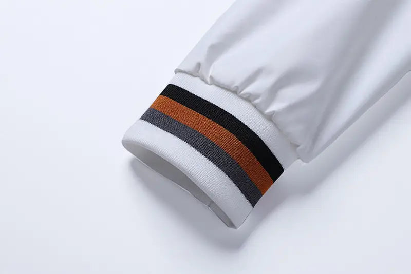 Manga de la chaqueta tipo bomber USA para hombre con tela blanca, con puño con gráfico de letras estilo varsity a rayas negro, gris y naranja, para uso casual.