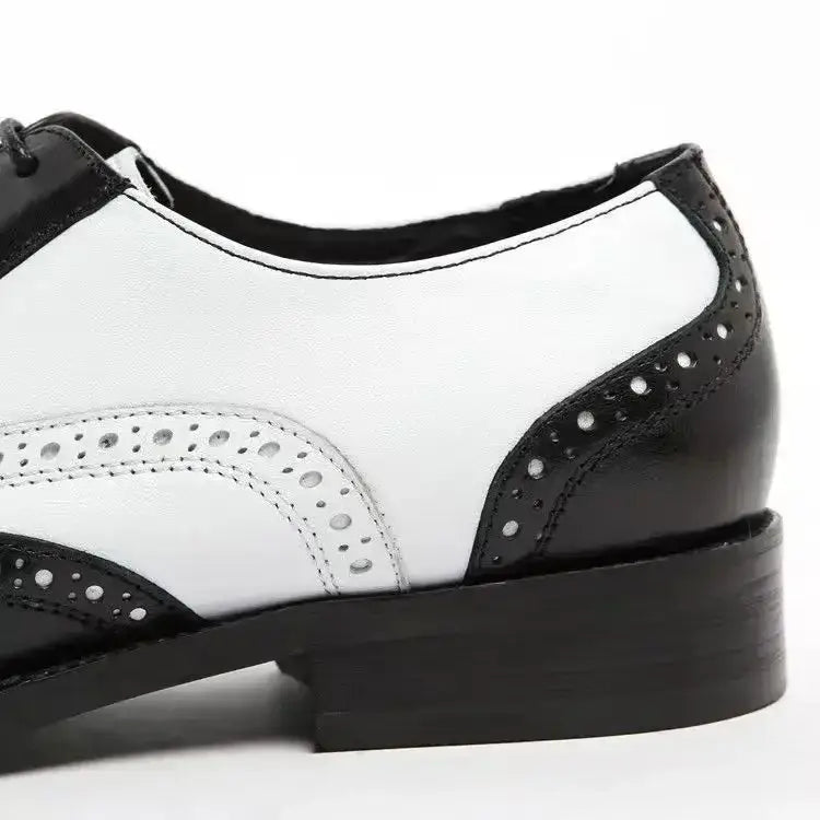Los zapatos de vestir tipo Oxford bicolor con costuras brogue para hombre en cuero negro y blanco con detalles perforados se muestran.