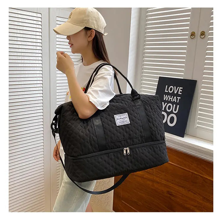 Bolsa de viaje tipo duffel acolchada negra tote weekender grande con asas dobles y una correa para el hombro desmontable.