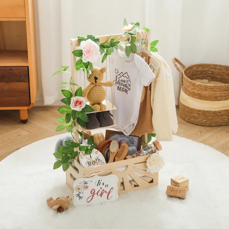 人工的なグリーンとピンクの花、かぎ針編みのテディベアで飾られた、木製のベビーストレージバスケットの収納、保育園の装飾。木製のベビーガール向けギフト用ディスプレイラック。