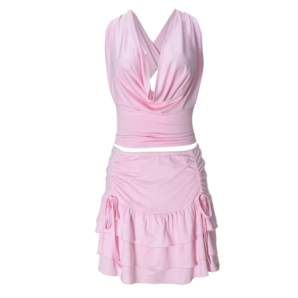 Ein zartrosa Zweiteiler-Minirock-Set mit drapiertem Neckholder-Top und gerafftem, mehrlagigem Rock mit Pullover-Verschlussart sowie seitlichen Schleifen.