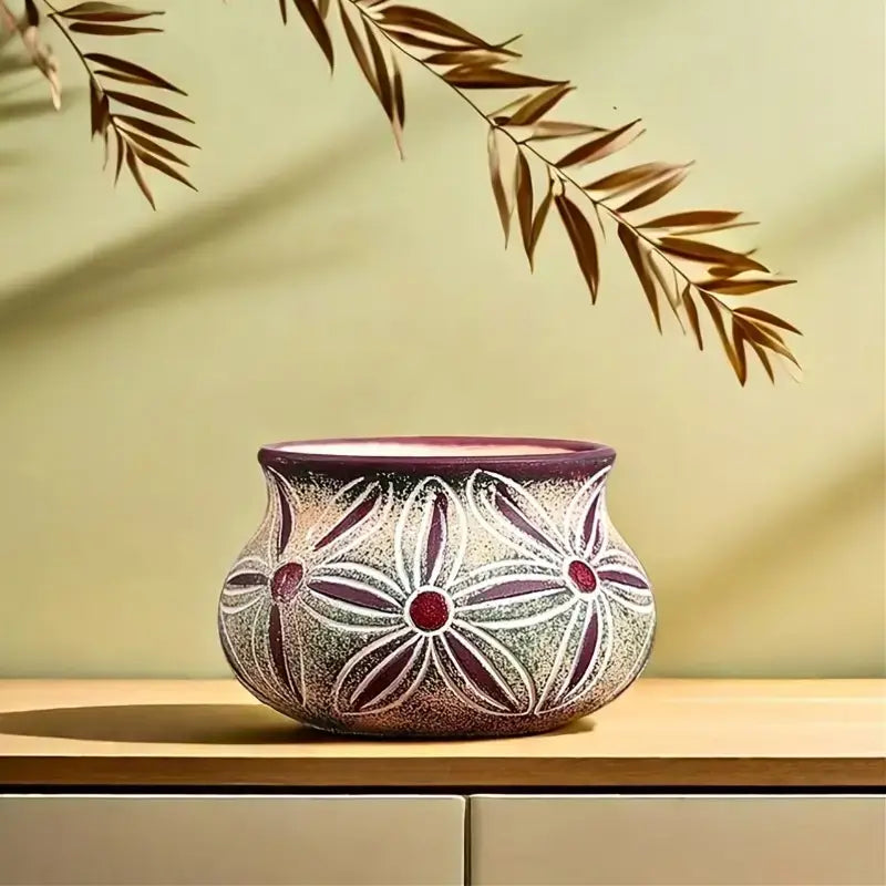 a handcrafted ceramic succulent planter pot with a rounded bulbous shape featuring intricate white floral patterns and deep burgundy accents highlighting the rim and flower centers with no visible packaging damage