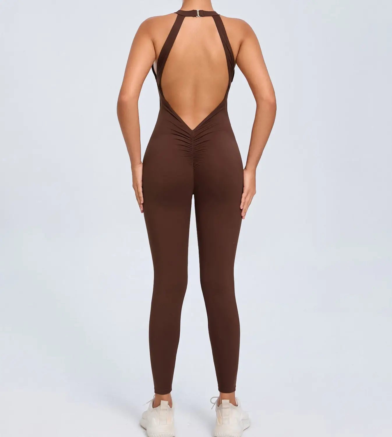 brown one-piece athletic jumpsuit with halter neckline and open back shown from the back for workout use