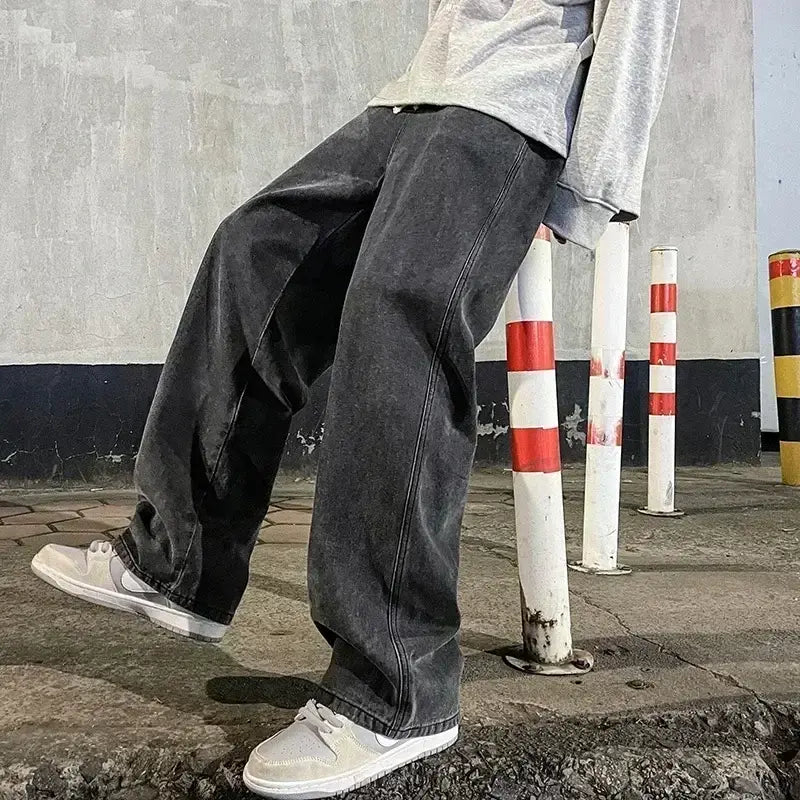 Jeans en denim à lavage foncé à jambes larges pour hommes, coupe décontractée à jambe droite et surpiqûres visibles le long des coutures, conçus pour un style streetwear coréen ample.