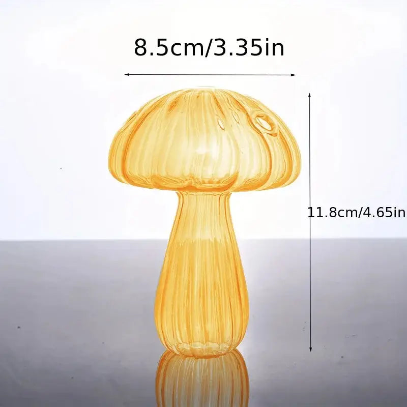 A translucent amber glass mushroom bud vase with a ribbed stem and cap measuring 8.5cm wide by 11.8cm tall used as a colorful Nordic plant holder.