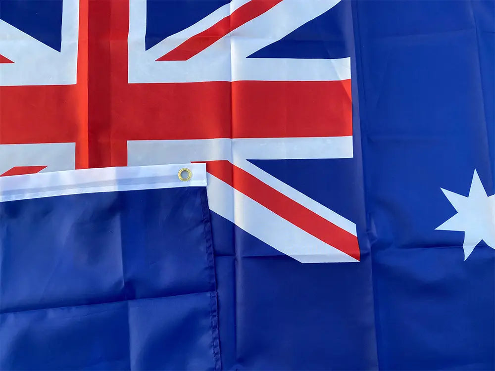 Bandera nacional australiana de 90x150 cm confeccionada con tela, con campo azul, aspa de la bandera británica roja y blanca en la esquina y una única estrella blanca en el lado derecho.