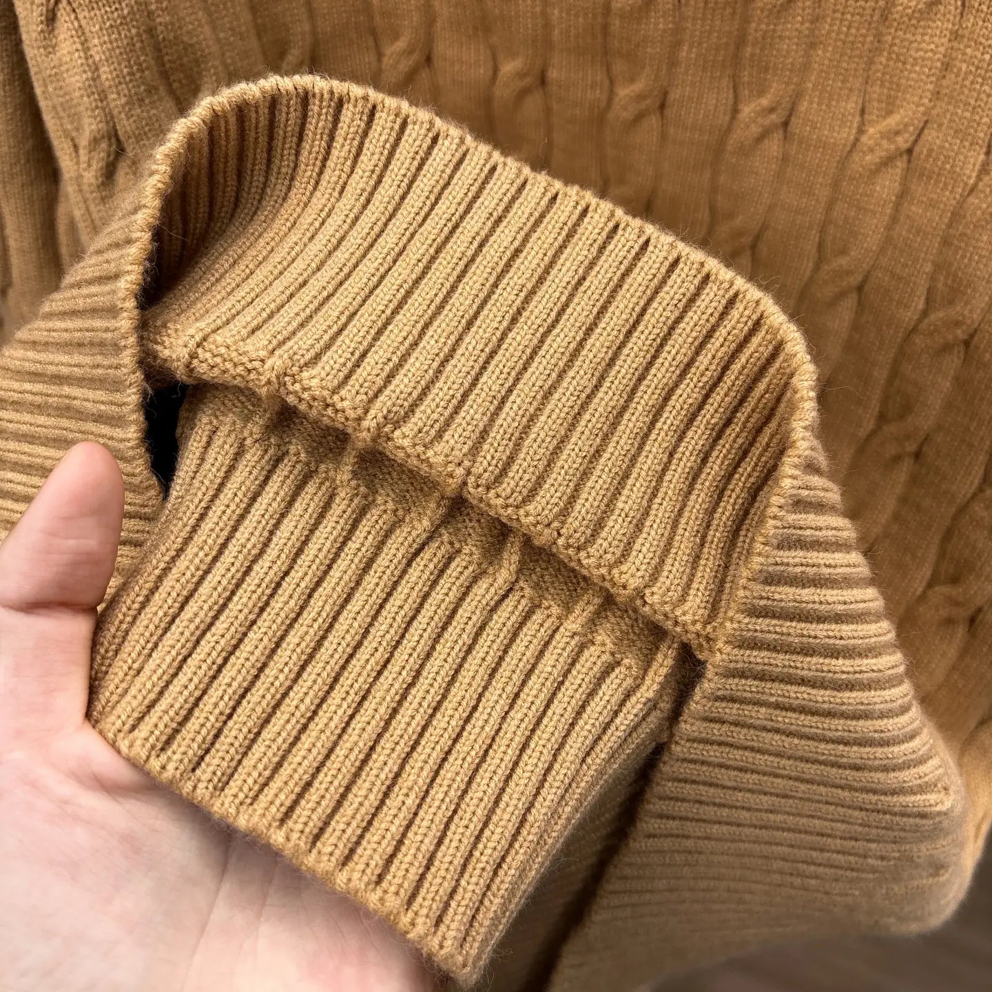 Ein gemütlicher Herren-Designer-Halbreißverschluss-Sweater aus camel-farbenem Zopfmusterstrick, mit geripptem Kragen und Bündchen.
