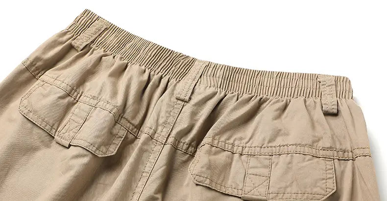 beige cotton men cargo pants with elastic waistband and multiple pockets designed for relaxed fit utility use.