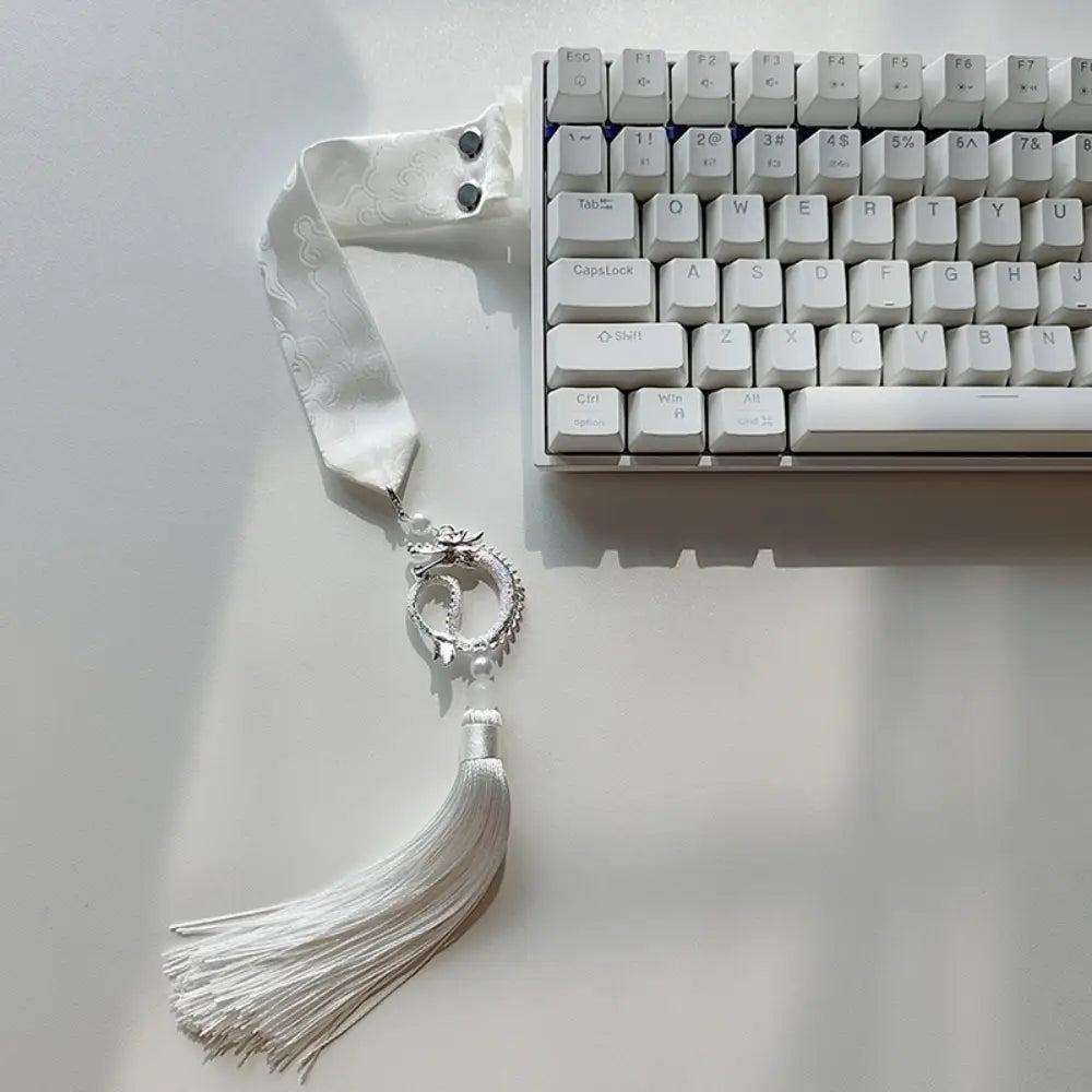 Sangle personnalisée pour le modèle Ribbon Dragon du clavier Wooting, comprenant un ruban brodé sur le thème du dragon argenté avec un pompon délicat.