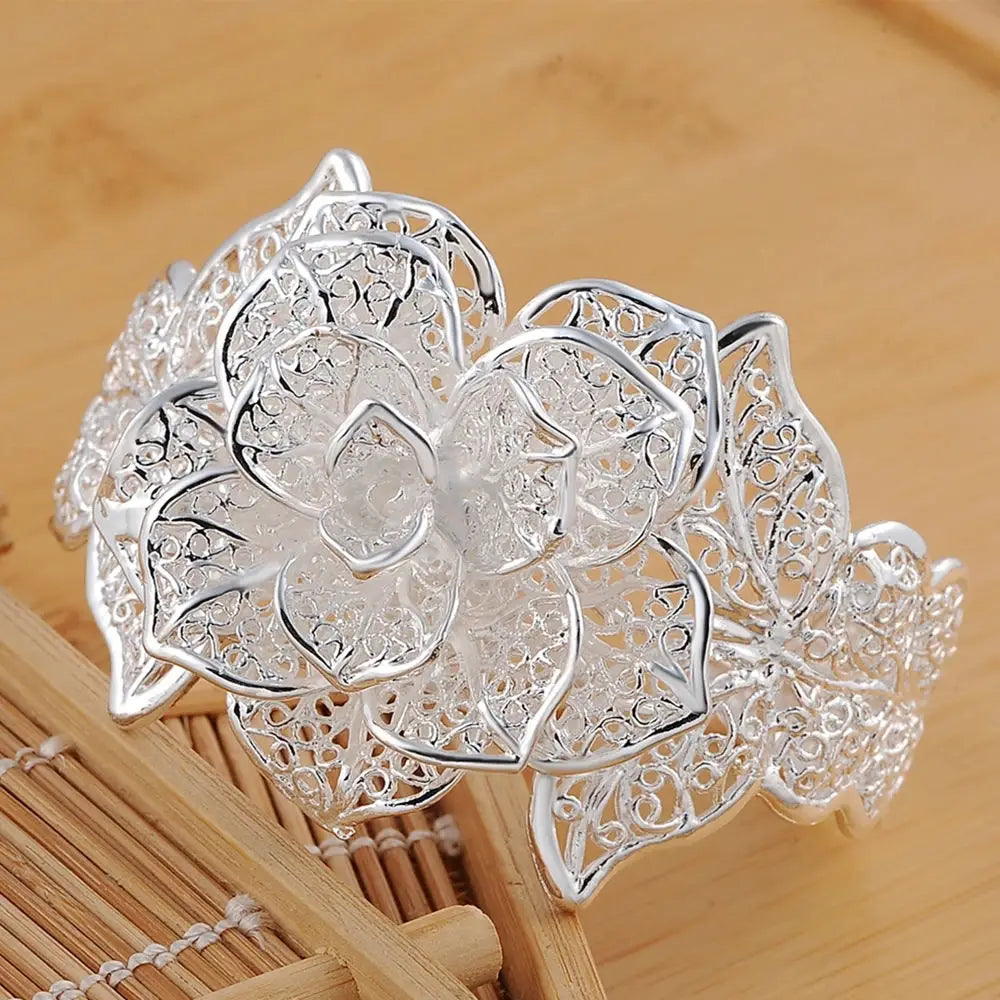 Parure de bijoux floraux en argent sterling comprenant un bracelet manchette de fleur en filigrane d’argent, avec des détails délicats de type dentelle et un motif ajouré délicat.