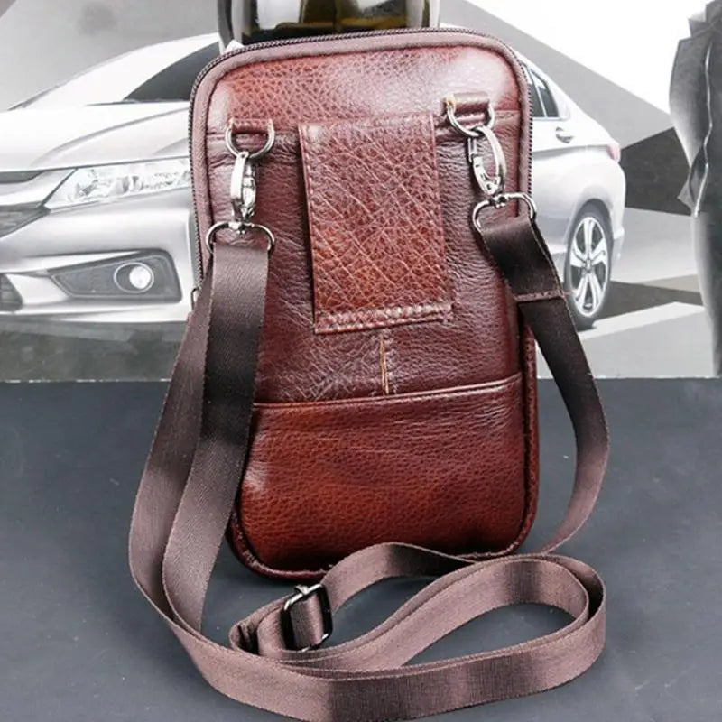 braune Ledergürteltasche für Herren mit strukturierter Oberfläche, verstellbarem Riemen und silberfarbenen Metallbeschlägen, entworfen als bequeme Gürteltasche und Umhängetasche für das Mobiltelefon.
