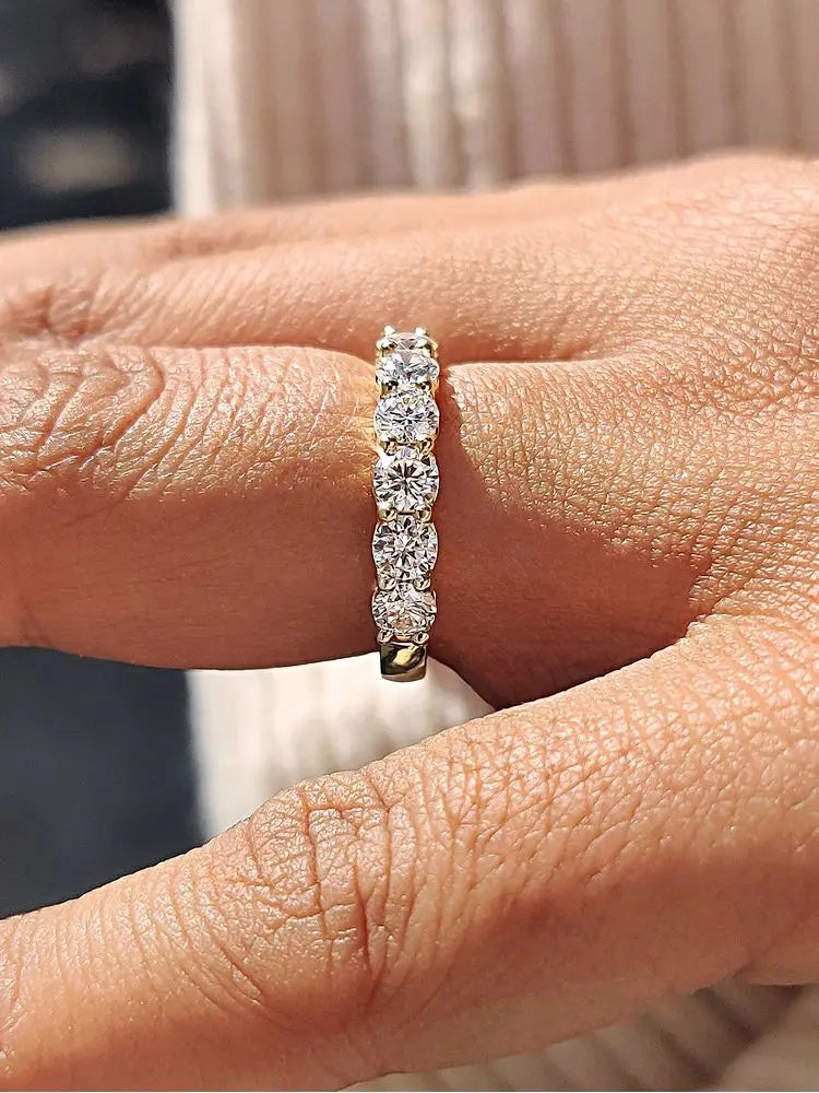 Sterling silver zircon wedding band for women in gold with five round-cut diamonds set in a continuous line.