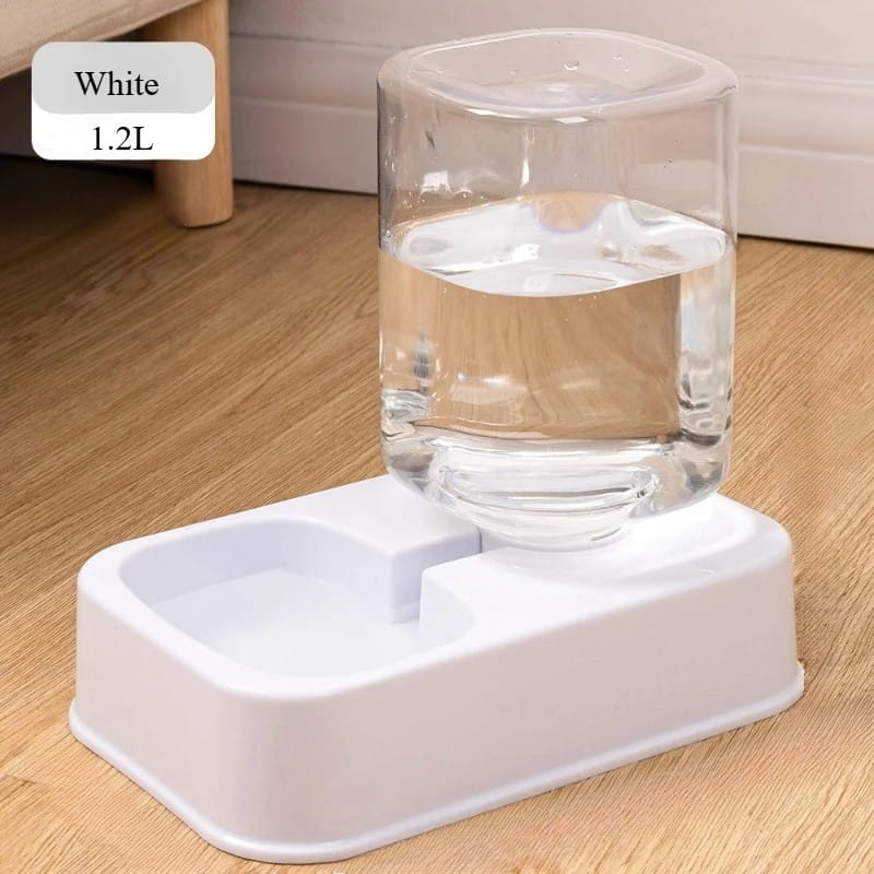 White plastic pet feeder and water dispenser with a clear 1.2 liter cylindrical reservoir and dual-compartment base for easy access to fresh drinking water.