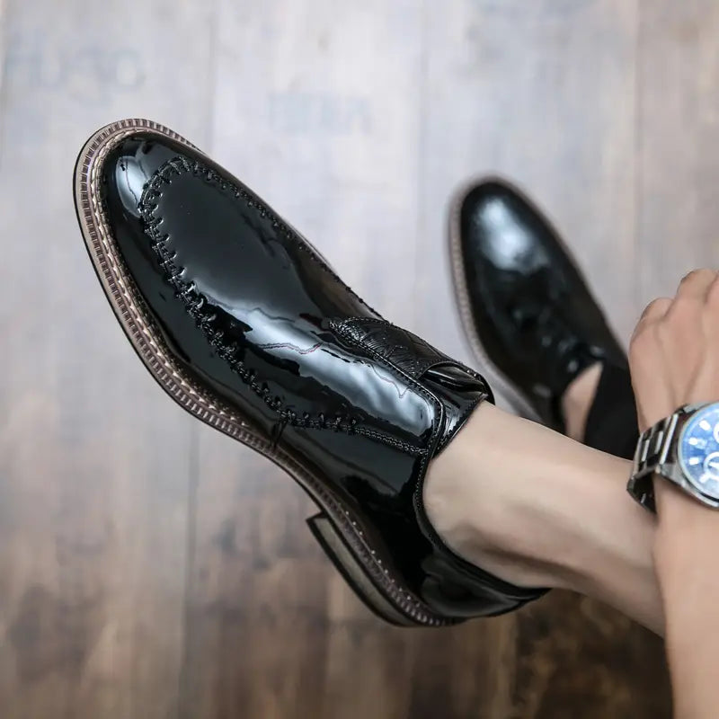 Herren glänzende Lackleder-Kleiderschuhe mit schwarzem Lackleder sowie braunen Nähten und kontrastierender hellbrauner Sohle.