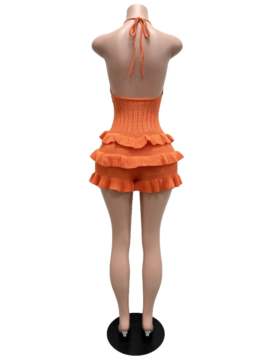 orange knitted halter romper with ruffled layers and tied back neckline suitable as a summer playsuit.