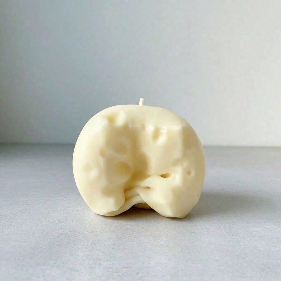 ein cremefarbener Käsewürfel-Stressball, geformt wie Käse mit glatter Wachsschicht und kleinen Löchern, die Schweizer Käse nachahmen, zur Sinneswahrnehmung