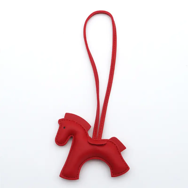 Porte-clés en cuir rouge en forme de cheval pour sac avec boucle assortie pour la fixation.