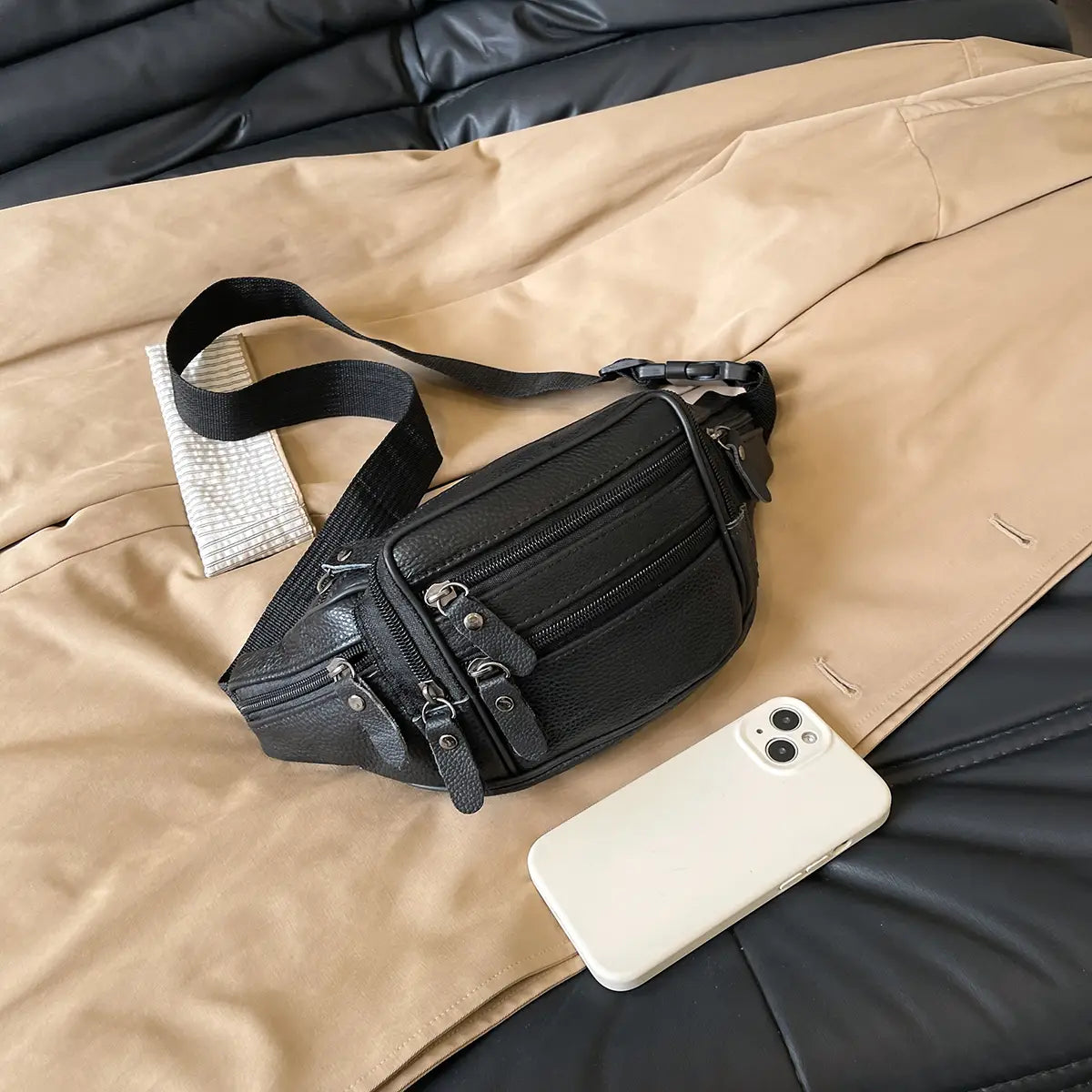 Schwarze Gürteltasche aus echtem Leder mit mehreren Reißverschlüssen und einem verstellbaren Riemen, entworfen als Crossbody-Bauchtasche.