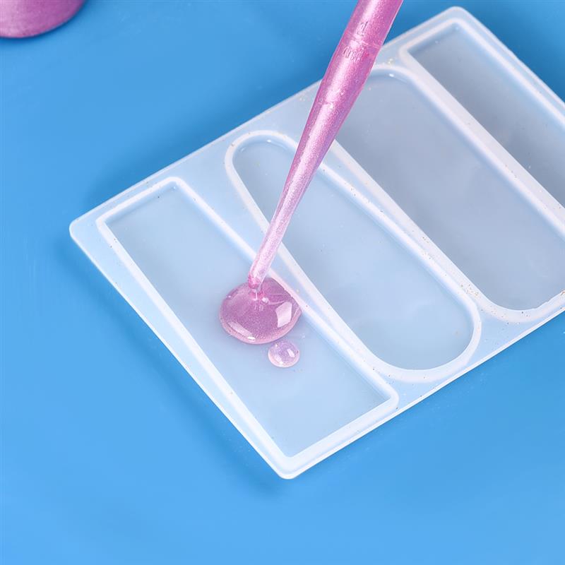 pink liquid is being dispensed from a pink dropper into a white silicone mold in the epoxy resin mixing tool set for diy jewelry making.