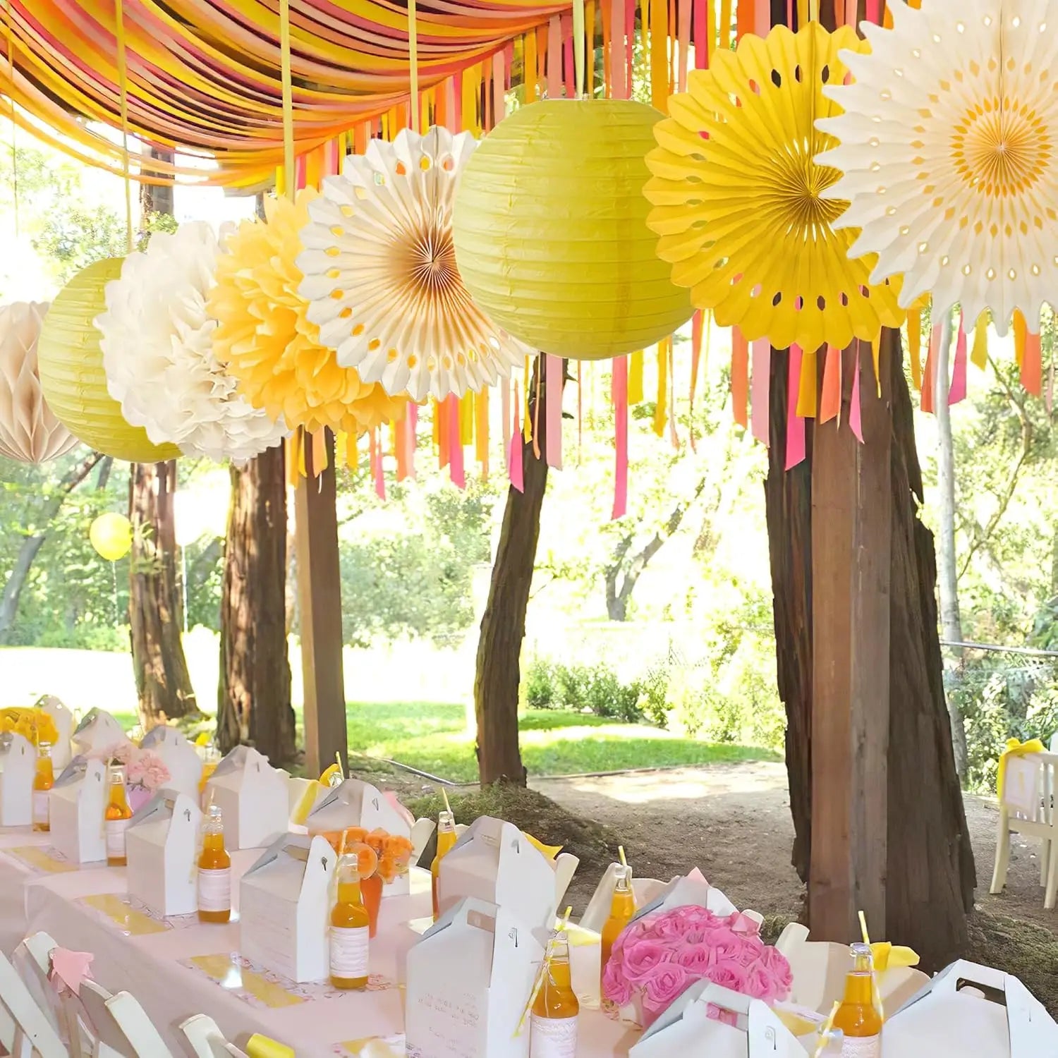 Lanternes en papier jaunes suspendues à une canopée de rubans colorés et d’éventails en papier, comme décorations de fête réalisées en papier.
