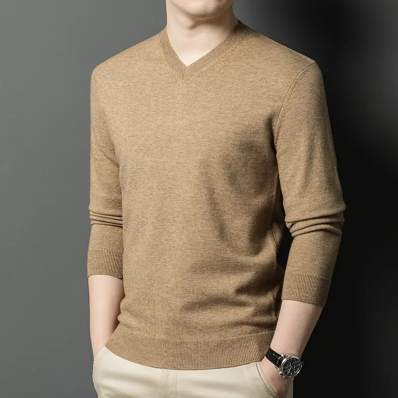 Ein Herren-V-Ausschnitt-Pullover in Camel-Farbe aus weichem Strickmaterial mit gerippten Bündchen und Saum.