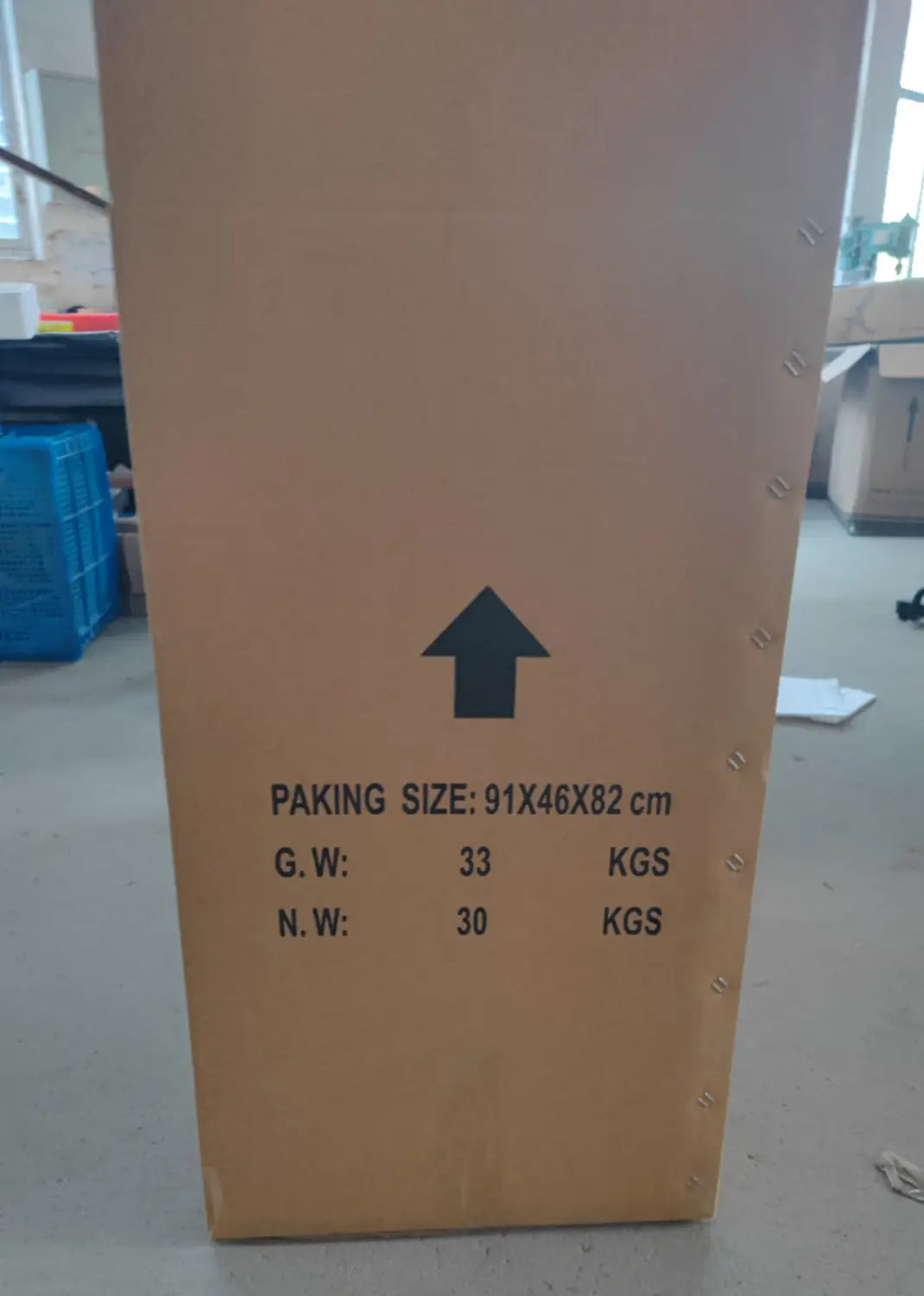 A tall brown cardboard shipping crate with black printed labeling and an upward-pointing arrow for horse riding exercise machine fitness equipment.