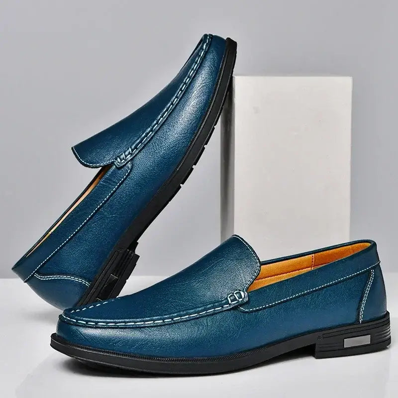 Deep blue men genuine leather slip-on dress loafers featuring contrasting white stitching and a black rubber sole.
