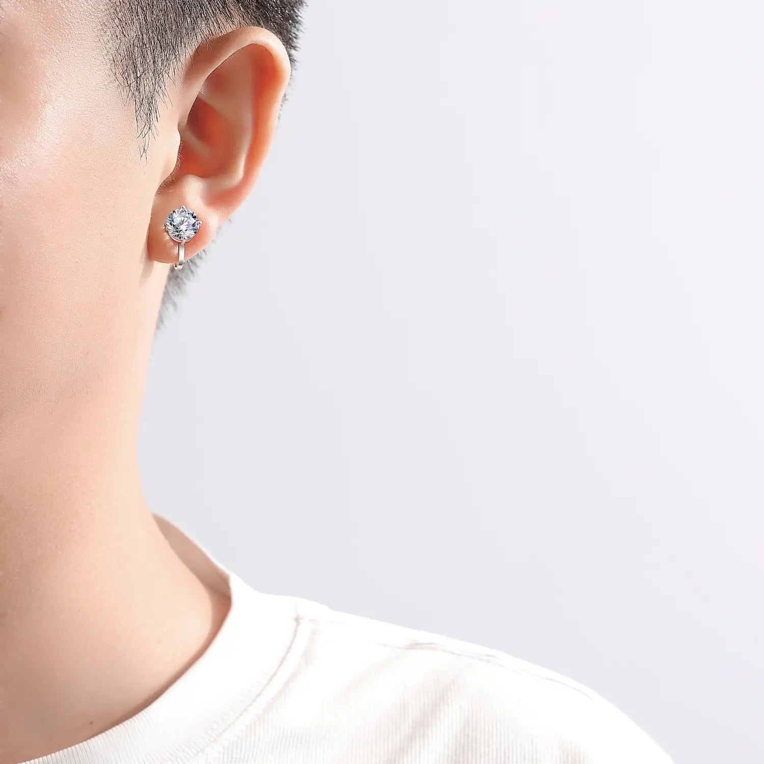 A sleek silver moissanite clip on earring featuring a round faceted crystal center set in 925 sterling silver.