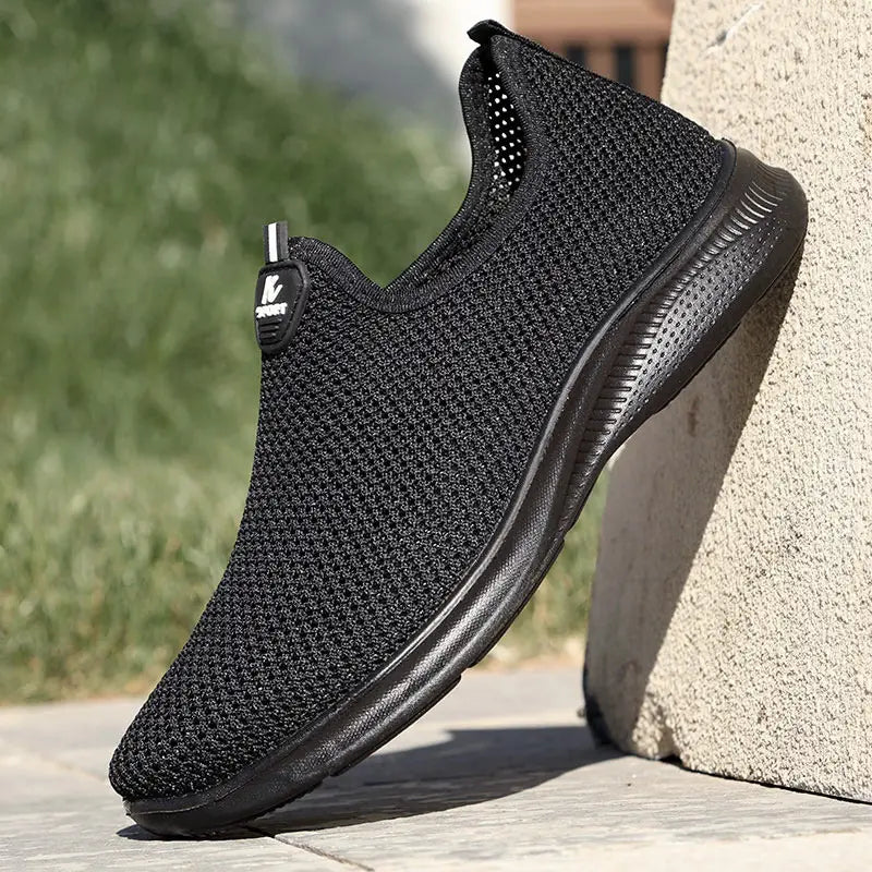 Baskets à enfiler pour hommes en mesh respirant de couleur noire, avec tige élégante et semelle en caoutchouc texturée, idéales pour un usage décontracté