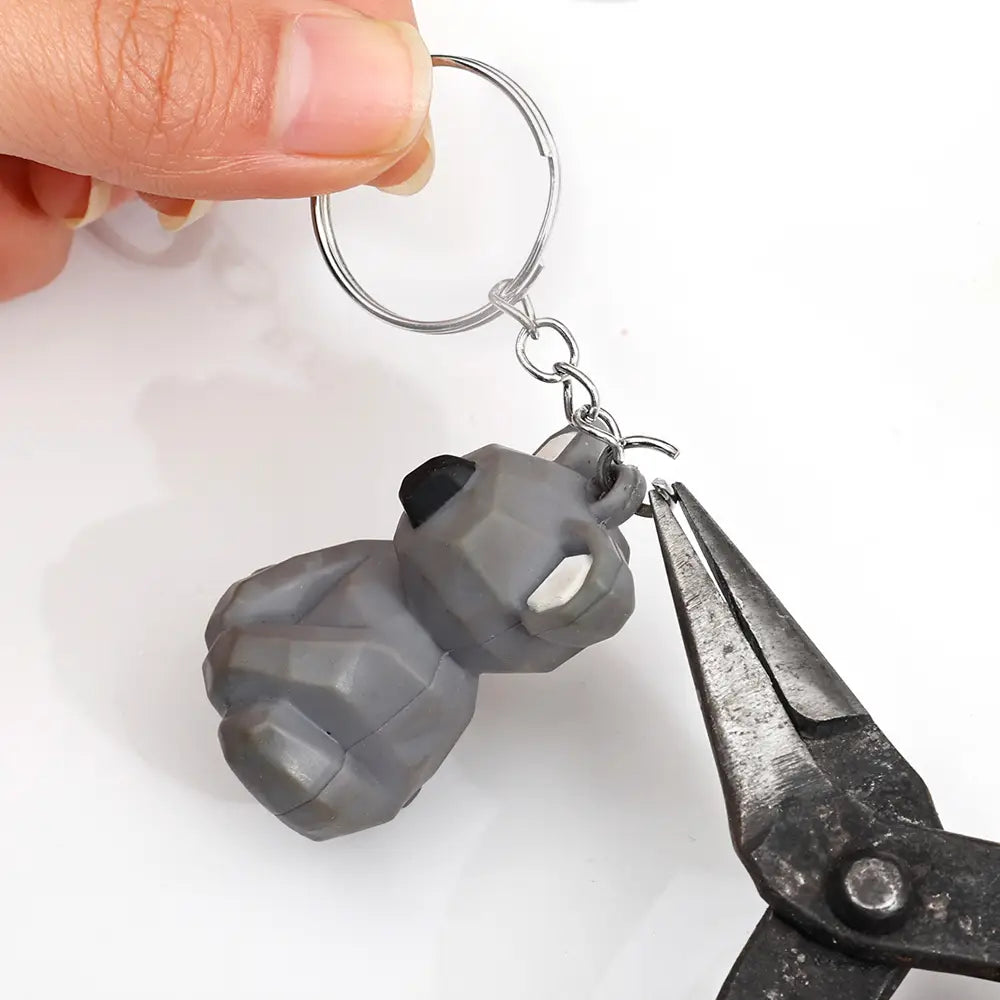Gray geometric panda metal keychain with black and white accents featuring a split ring and chain for easy attachment.
