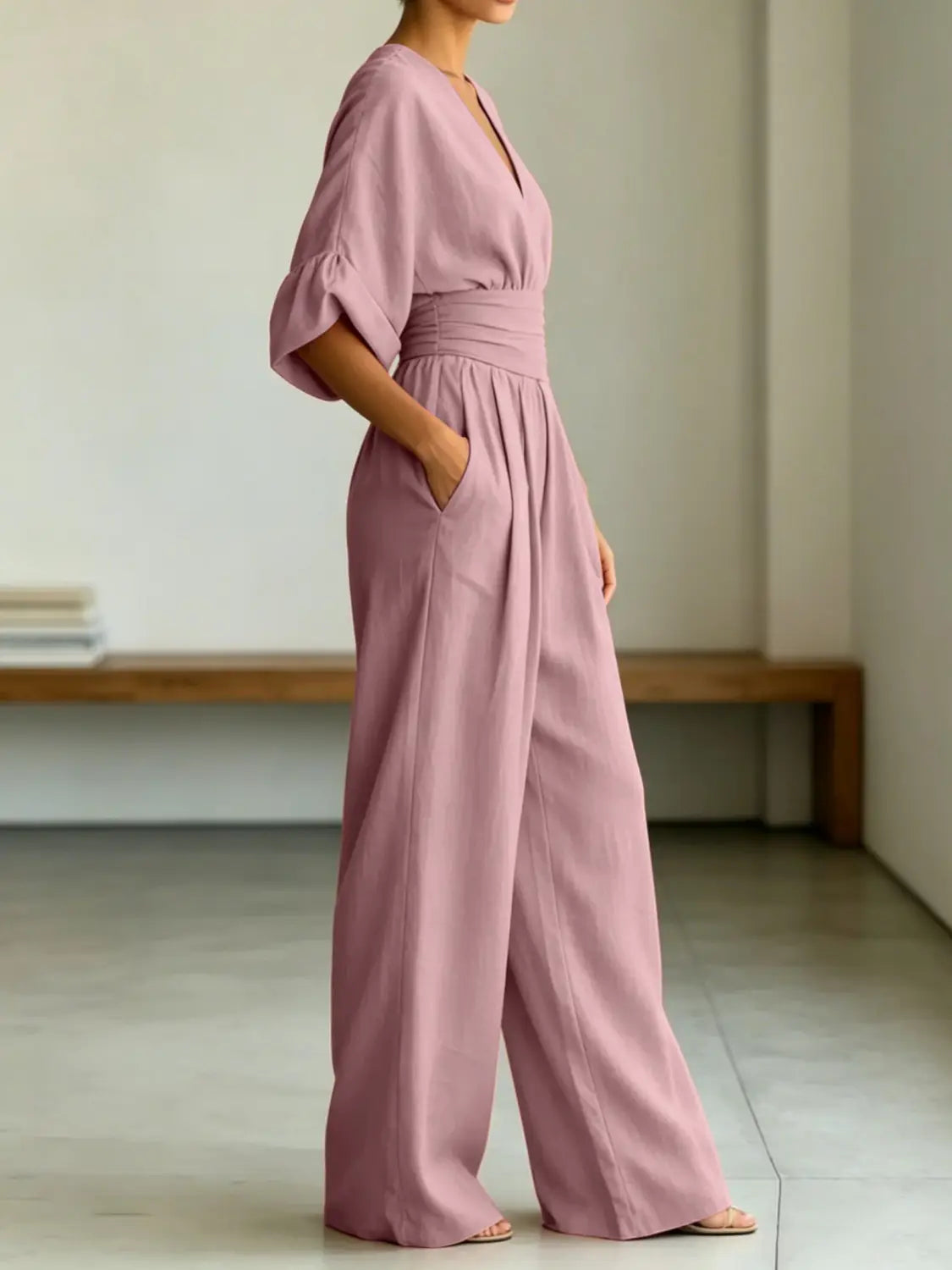 A soft lavender-colored wide-leg jumpsuit with a v-neckline and puffed sleeves.