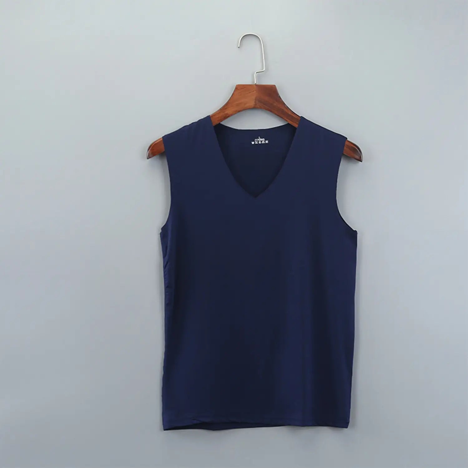 Navy blue men ice silk sleeveless tank top with v-neckline hanging on a wooden hanger.