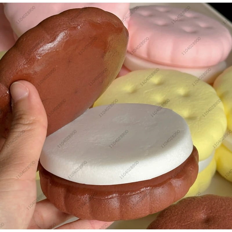 Ein braun strukturiertes Silikon-Slow-Rising-Großkeks-Knautschspielzeug mit einer weißen Cremefüllung, die einem realistischen Kuchen ähnelt.