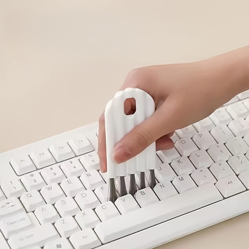 White plastic keyboard cleaning brush with metal bristles included in a keyboard stand and cleaning brush set for effective dust removal.