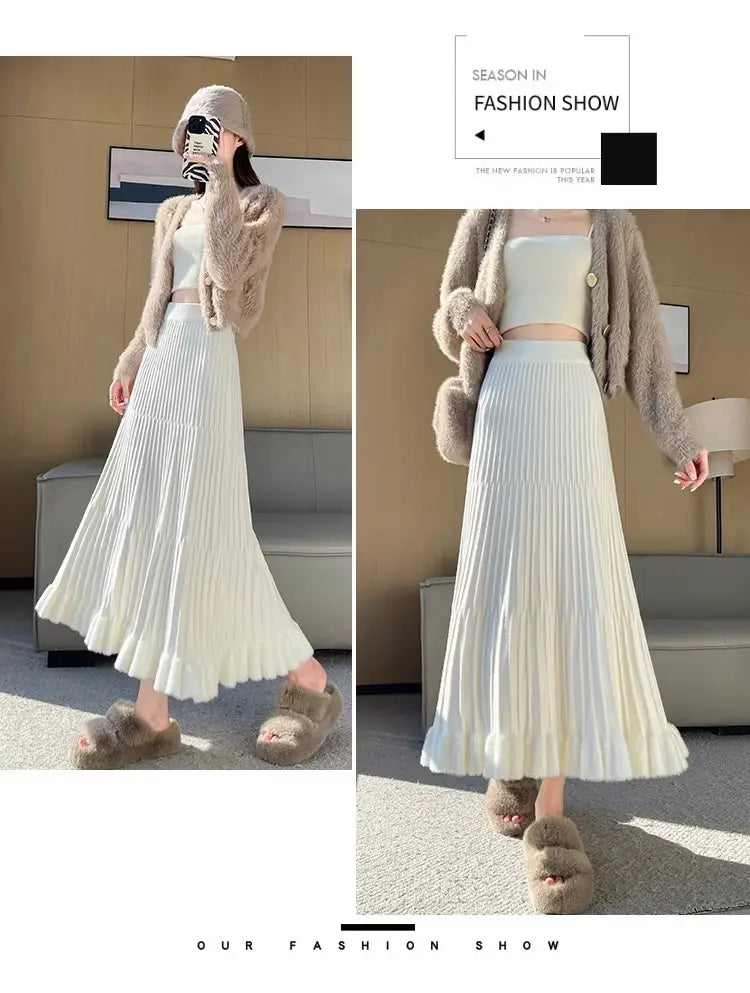 Une jupe mi-longue en maille blanche fluide, avec design parapluie à plis et taille haute flatteuse, réalisée dans un tissu à texture douce.