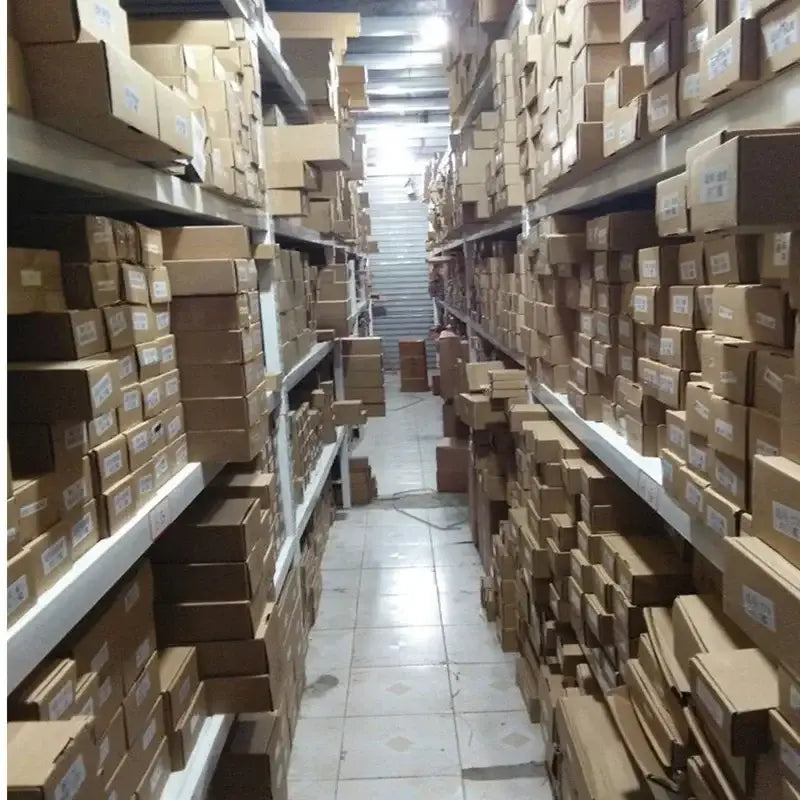 Rows of brown cardboard boxes containing vw passat door handle cover trim made of carbon fiber are stacked on metal shelves in a warehouse aisle.