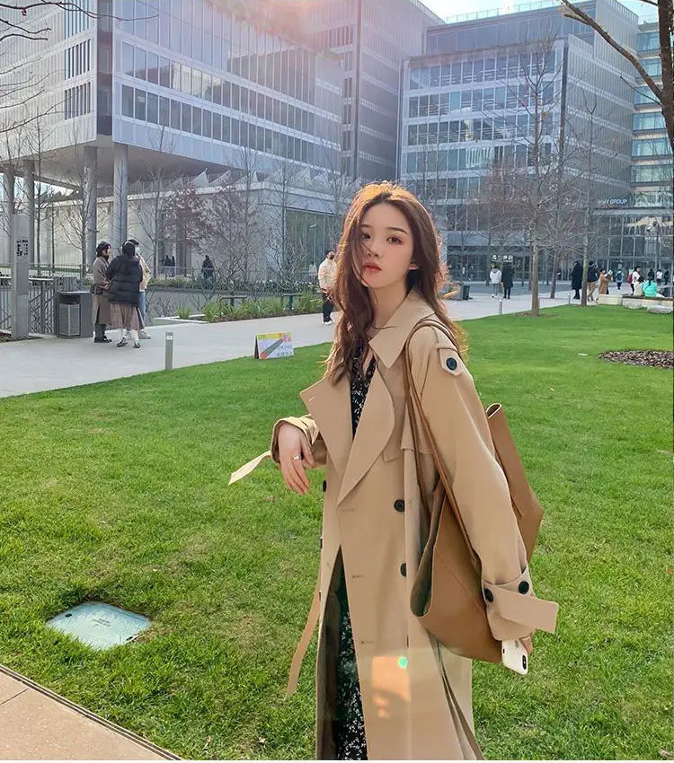 Beige women double breasted trench coat with black buttons and a structured collar made from durable fabric for stylish outerwear.