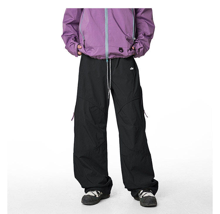 pantalones cargo impermeables de senderismo para hombre en negro, con múltiples bolsillos y cinturilla con cordón, combinados con una chaqueta morada para un rendimiento de secado rápido